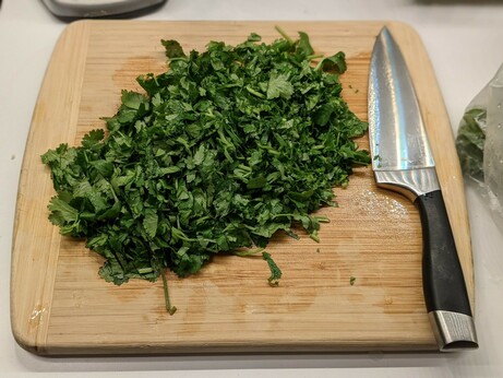 Cilantro roughly chopped across the cutting board.