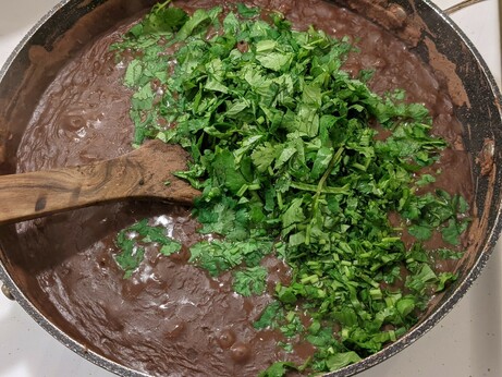 Pan full of much smoother mashed beans plus a huge bright swath of cilantro on top.
