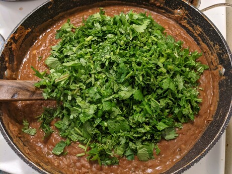 Smoother beans, now covered with a generous pile of chopped cilantro leaves and stems.