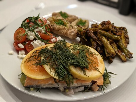 The same meal but from a lower angle, showing the salmon peeking out from beneath three slices of citrus and a pile of dill.